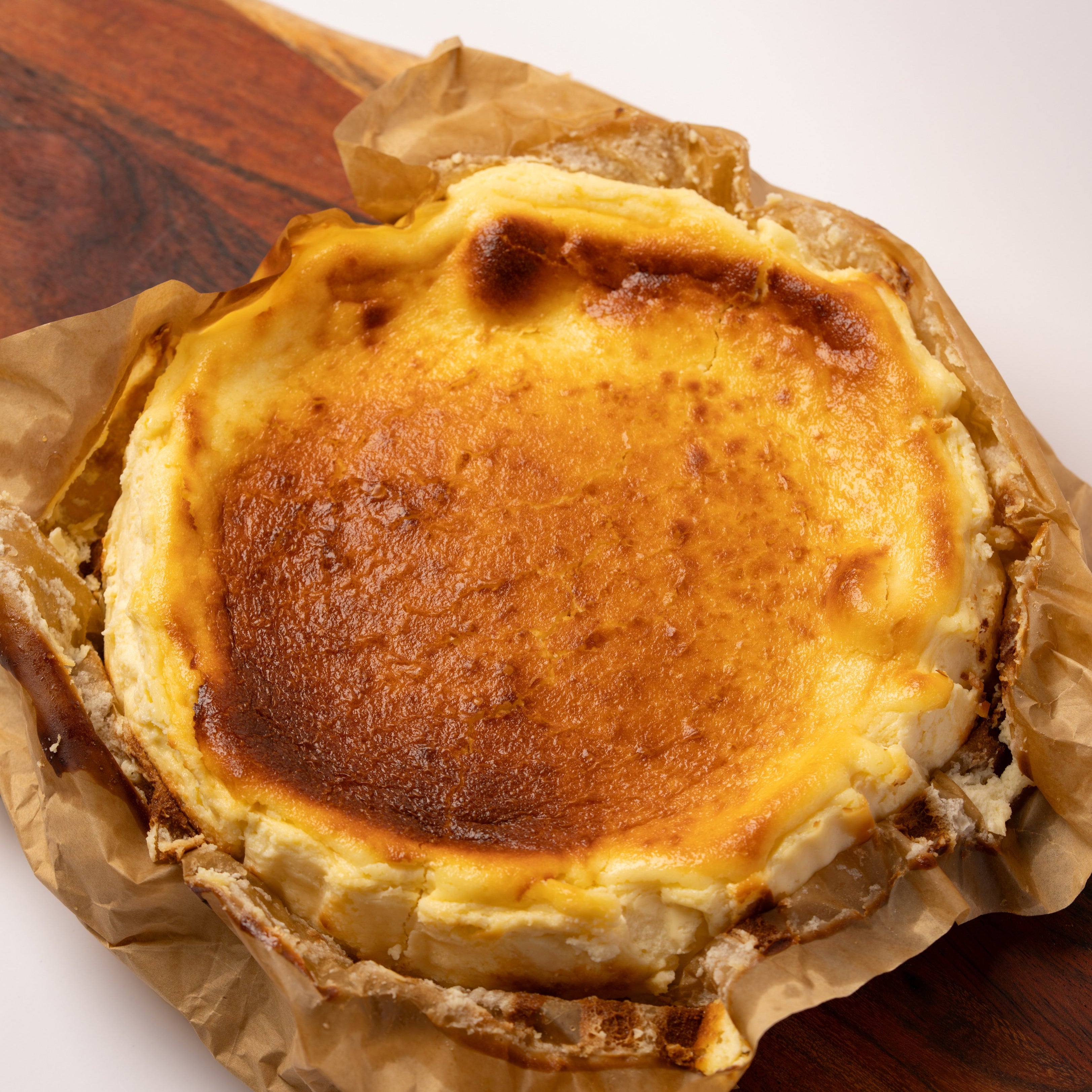 Baked custard tart on a wooden board with brown paper
