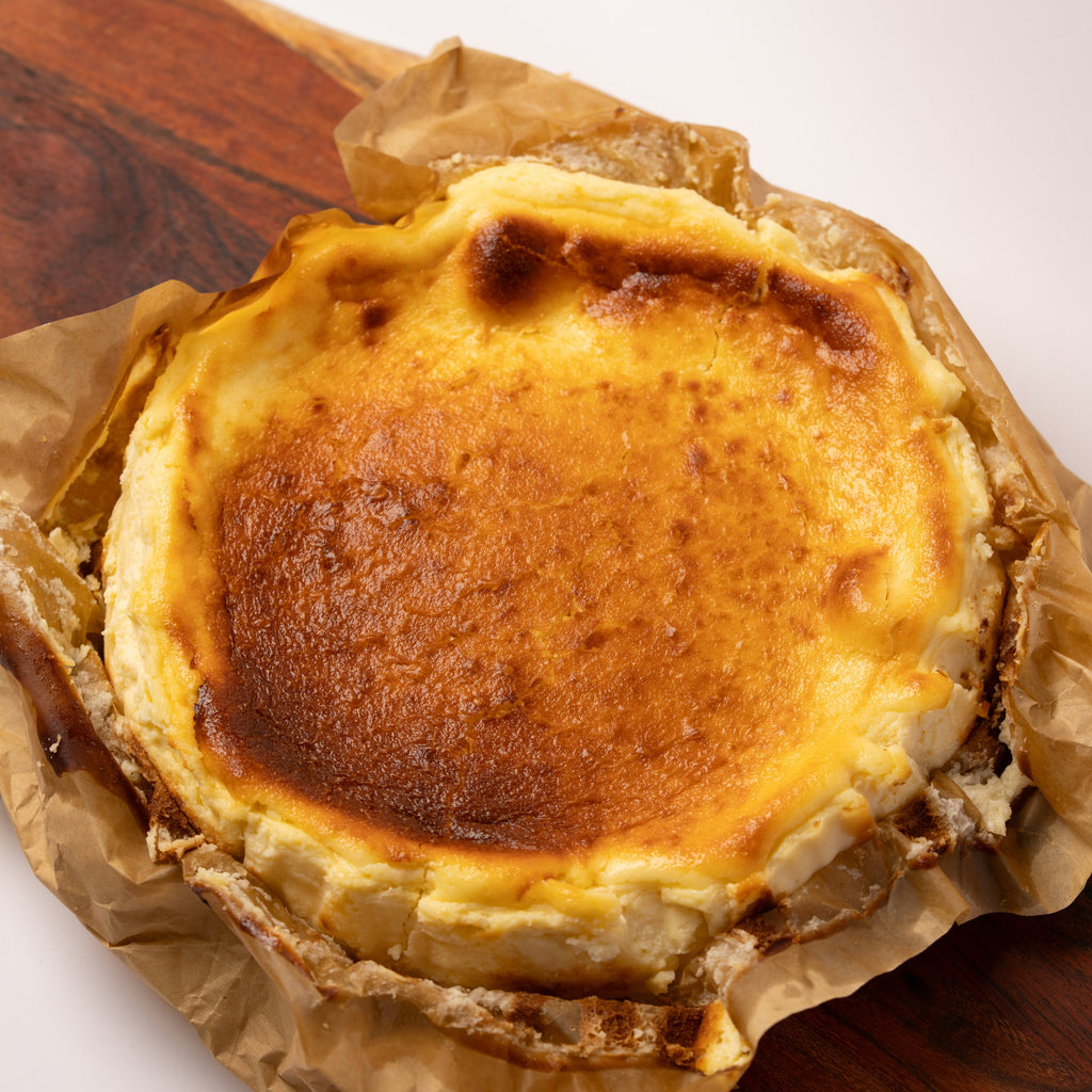 Baked custard tart on a wooden board with brown paper
