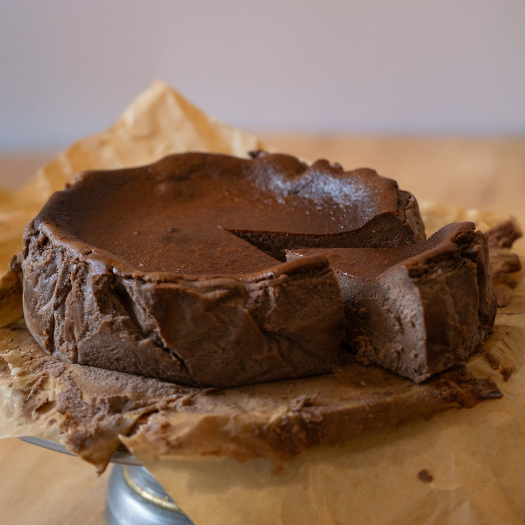 Chocolate cake with a slice removed on brown paper